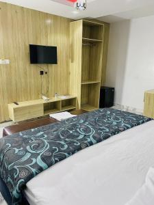 a bedroom with a large bed and a television at Wesmont Hotels in Ikorodu
