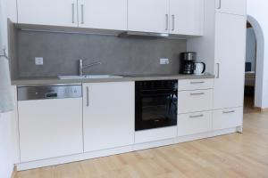 a kitchen with white cabinets and a sink at Casa Carinthia in Samnaun +9 photos