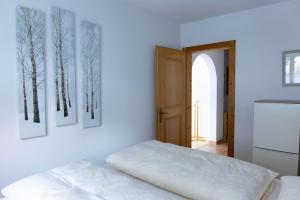 a bedroom with three pictures of trees on the wall at Casa Carinthia in Samnaun