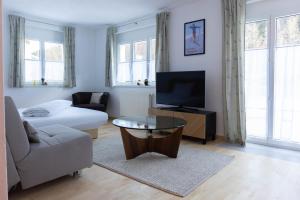 a living room with a couch and a flat screen tv at Casa Carinthia in Samnaun