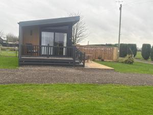 a small cabin with a deck in a yard at The paddocks in Wisbech +8 photos