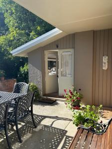 a patio with a table and a bench and flowers at McIvor Lodge in Invercargill