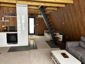a living room with a staircase in a house at A Frame house Slavuljica in Vlasic