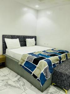 a bedroom with a bed with a blue and white comforter at Wesmont Hotels in Ikorodu