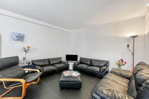 a living room with a leather couch and chairs at Menaggio 57 in Menaggio