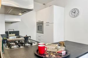 a kitchen with a counter with a plate and a clock at Menaggio 57 in Menaggio +29 photos
