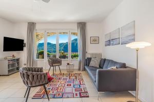 a living room with a couch and chairs and a television at Villa Tremezzo in Tremezzo