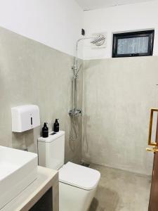 a bathroom with a white toilet and a shower at La Manga Mirissa in Mirissa