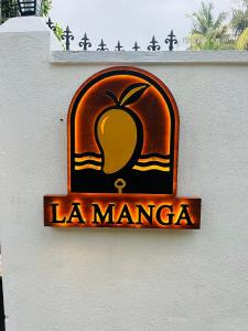 a sign on the side of a building with an apple at La Manga Mirissa in Mirissa