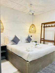 a bedroom with a bed with white sheets and blue pillows at La Manga Mirissa in Mirissa
