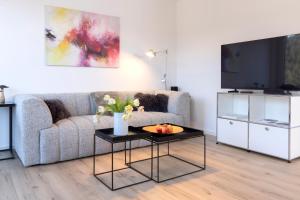 a living room with a couch and a tv at Buhlbach, Black Forest Retreat, mit Sonnenterrasse in Baiersbronn