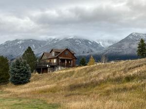 a house on a hill with mountains in the background at Yellowstone House in Livingston