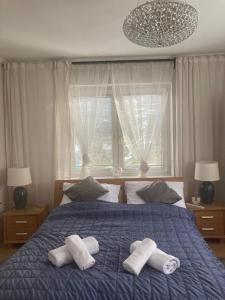 a bedroom with a blue bed with two towels on it at Willa Zakopane Center in Zakopane