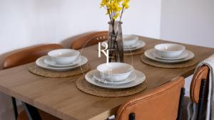 a wooden table with plates and cups and a vase with flowers at The Den at Braehead in Cruden Bay