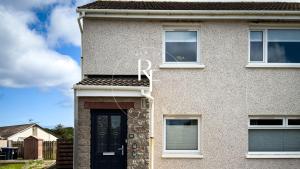 a house with a black door and windows at The Den at Braehead in Cruden Bay