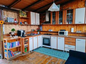 a kitchen with white cabinets and a stove top oven at Carpatina A-Frame Retreat - Rustic Cabins for Couples in Runcu