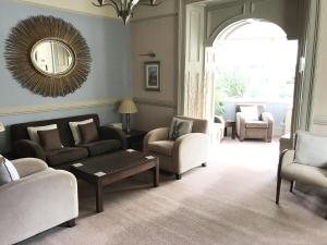 a living room with couches and chairs and a mirror at The Abbotsford in Callander