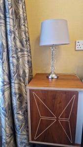 a table with a lamp on top of a dresser at The Abbotsford in Callander +2 photos