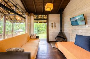 a living room with a couch and a fireplace at Pousada Watu Kerere in Praia do Rosa