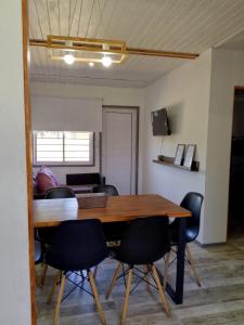 a dining room with a table and black chairs at Casa Uno in Paso de la Patria