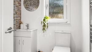 a bathroom with a toilet and a sink and a window at The Den at Catto in Peterhead +2 photos