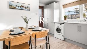 a kitchen with a wooden table and chairs and a sink at The Den at Catto in Peterhead