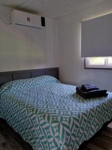 a bedroom with a bed with a blue and white comforter at Casa Uno in Paso de la Patria