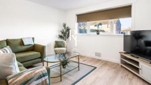 a living room with a couch and a glass table at The Den at Catto in Peterhead