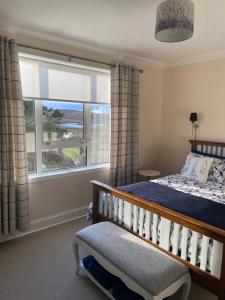 a bedroom with a bed and a large window at Tigh-na-Greine in Carloway