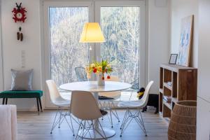 a dining room with a white table and chairs at Hermine, Black Forest Retreat, mit Sonnenterrasse in Baiersbronn +10 photos