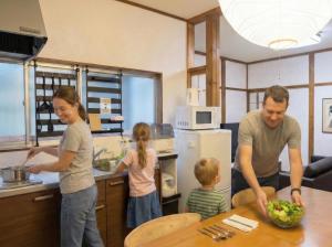 a man and a woman and two children in a kitchen at Private House HidaTakayama - Cozy Family Home in Takayama