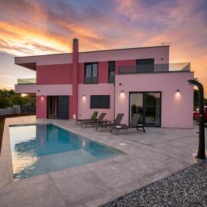 a house with a swimming pool in front of it at Relaxing Villa Giardin in Premantura