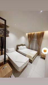 a bedroom with two beds and a window at Igli Hotel in Lezhë