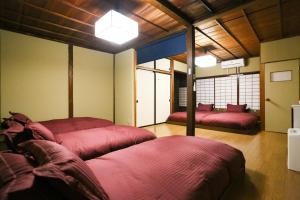 a bedroom with two red beds in a room at Private House HidaTakayama - Cozy Family Home in Takayama