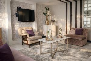 a living room with a table and two chairs and a tv at Casa Lolita Hotel-Boutique in Portoviejo