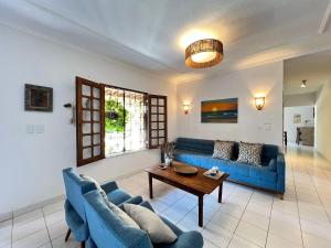 a living room with a blue couch and a table at Villa Wiktor Paracuru in Paracuru