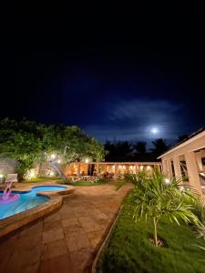 a backyard with a swimming pool at night at Villa Wiktor Paracuru in Paracuru