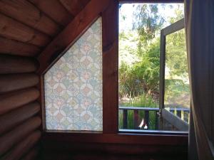 two windows in a room with a view of a porch at Tannenhof Countryside Log Cabins in Sanddrif