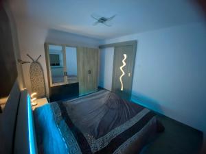 a blue room with a bed with a ceiling fan at Au refuge de David et Leah in Willer-sur-Thur