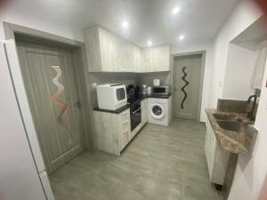 a small kitchen with a sink and a microwave at Au refuge de David et Leah in Willer-sur-Thur