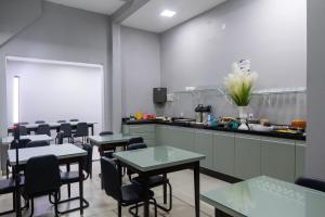 a restaurant with tables and chairs in a kitchen at GB Hotéis Foz Centro in Foz do Iguaçu