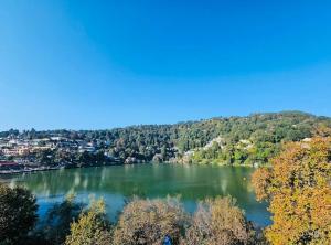 a view of a lake with trees and houses at Naini Hill View Boho in Nainital +41 photos