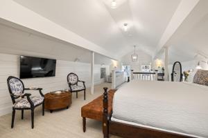 a bedroom with a bed and two chairs and a tv at The Davenport Inn in Portsmouth