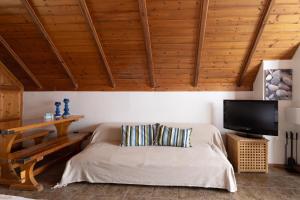 a bedroom with a bed and a flat screen tv at Myrto's Memories "My Sofitaki"- Seaview Studio in Melíssion