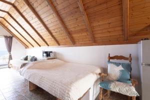 a bedroom with two beds and a wooden ceiling at Myrto's Memories "My Sofitaki"- Seaview Studio in Melíssion