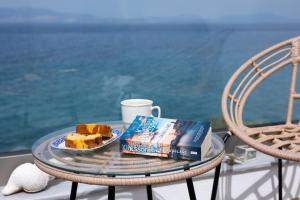 a table with a plate of cake and a book at Myrto's Memories "My Sofitaki"- Seaview Studio in Melíssion