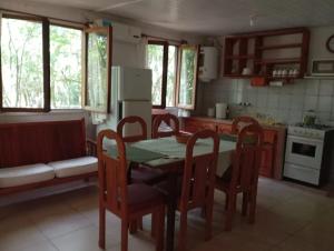 a kitchen with a table and chairs and a stove at Chacra Mariposas in Oberá +7 photos