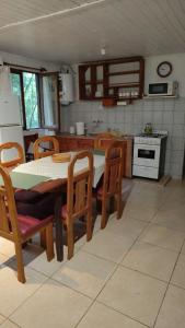 a kitchen with a table and chairs and a table and a stove at Chacra Mariposas in Oberá