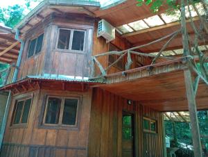 a wooden house with a balcony on top of it at Chacra Mariposas in Oberá