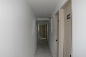 a corridor of a hallway with white walls and white floors at Hotel Casa Camoa in Villavicencio